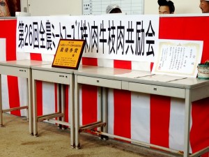 2025年11月7日(金)　JA全農ミートフーズ(株)肉牛枝肉共励会　セリ場　入賞牛購買者記念品と最優秀賞牛出品者への賞状